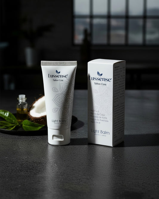 Lussense Light Balm tattoo care tube and box with coconut and green leaves. Natural tattoo balm for hydration and color enhancement.